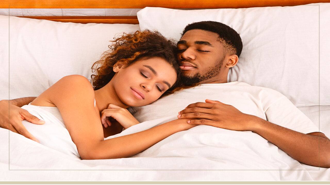Casal dormindo agarradinho sobre os Travesseiros Ortobom Casadinho 