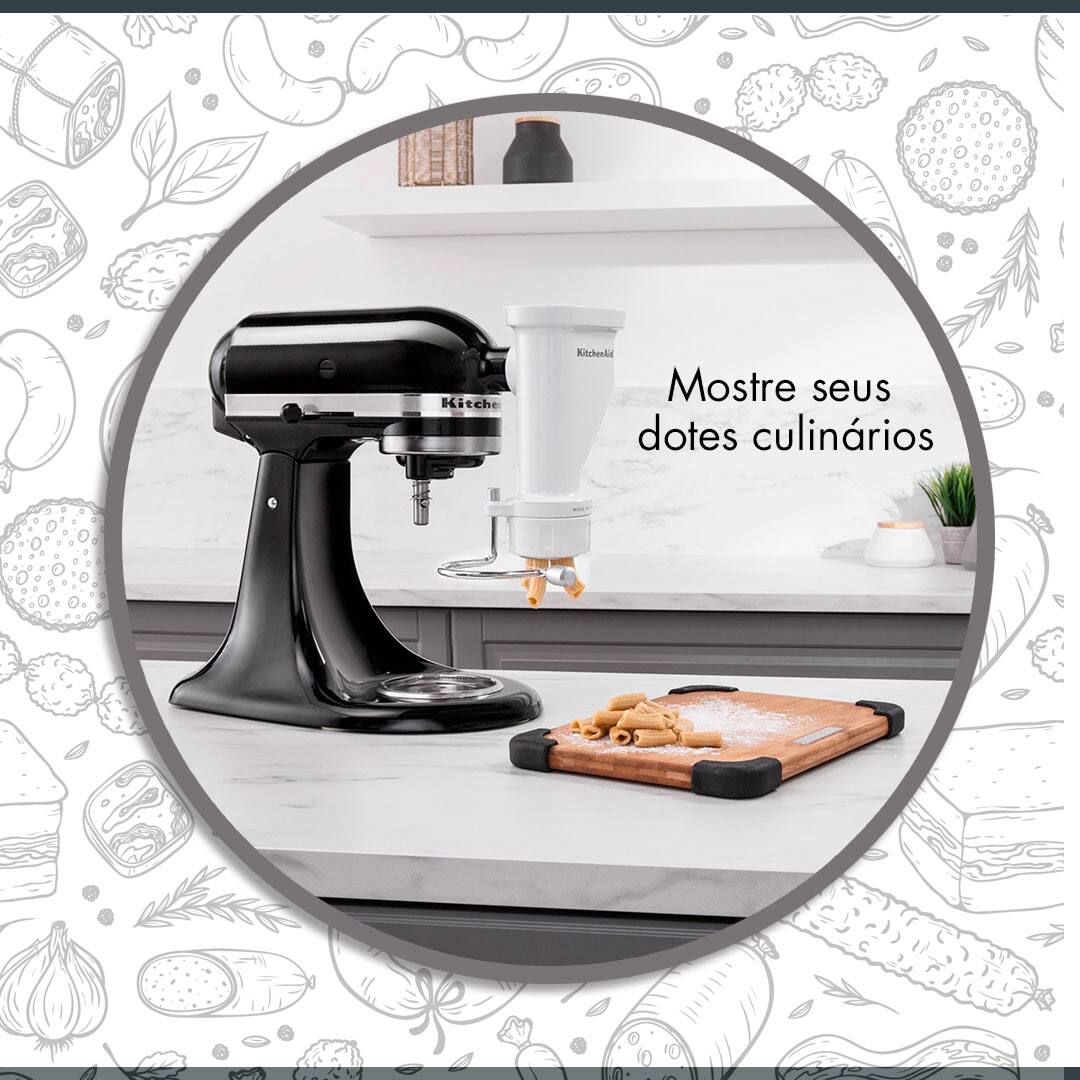 mostre seus dotes culinários batedeira KitchenAid preta prata cinza mesa bancada branca tábua marrom madeira massa cortada pedaços cortados macarrão penne fundo objetos decorativos vaso planta verde