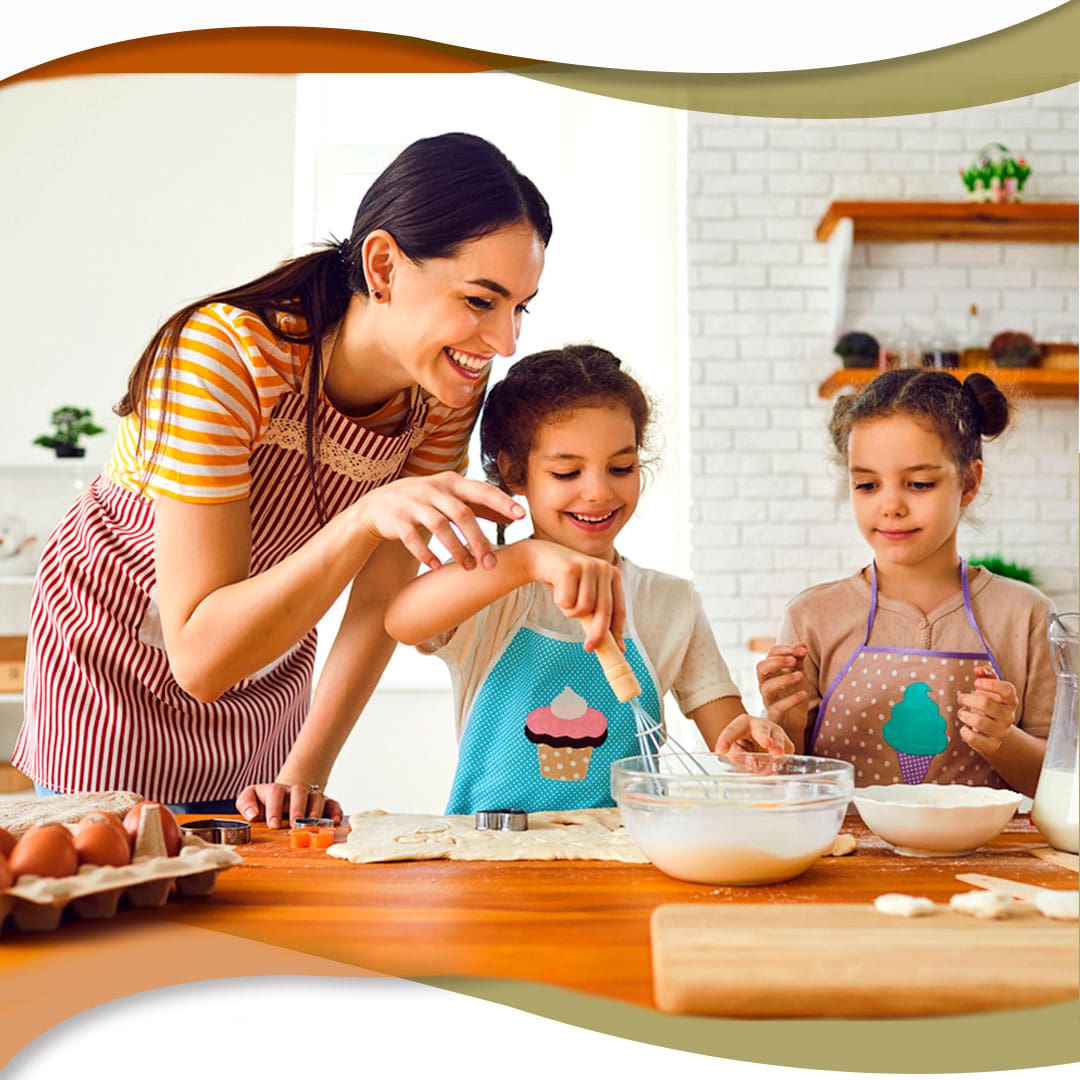 Mãe e filhas preparando uma massa de bolo