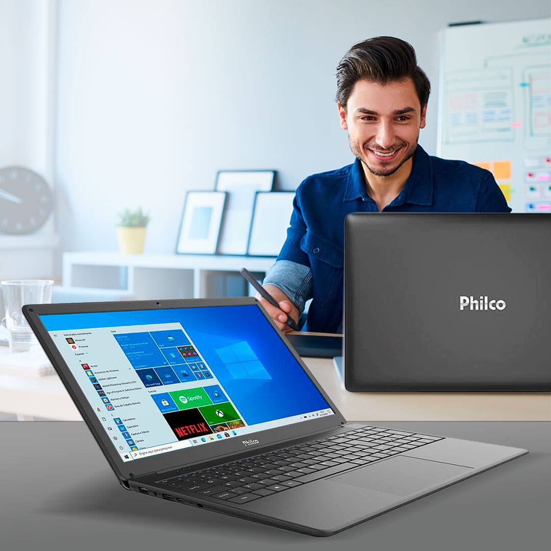 homem utilizando o notebook e aparelho aberto mostrando a tela