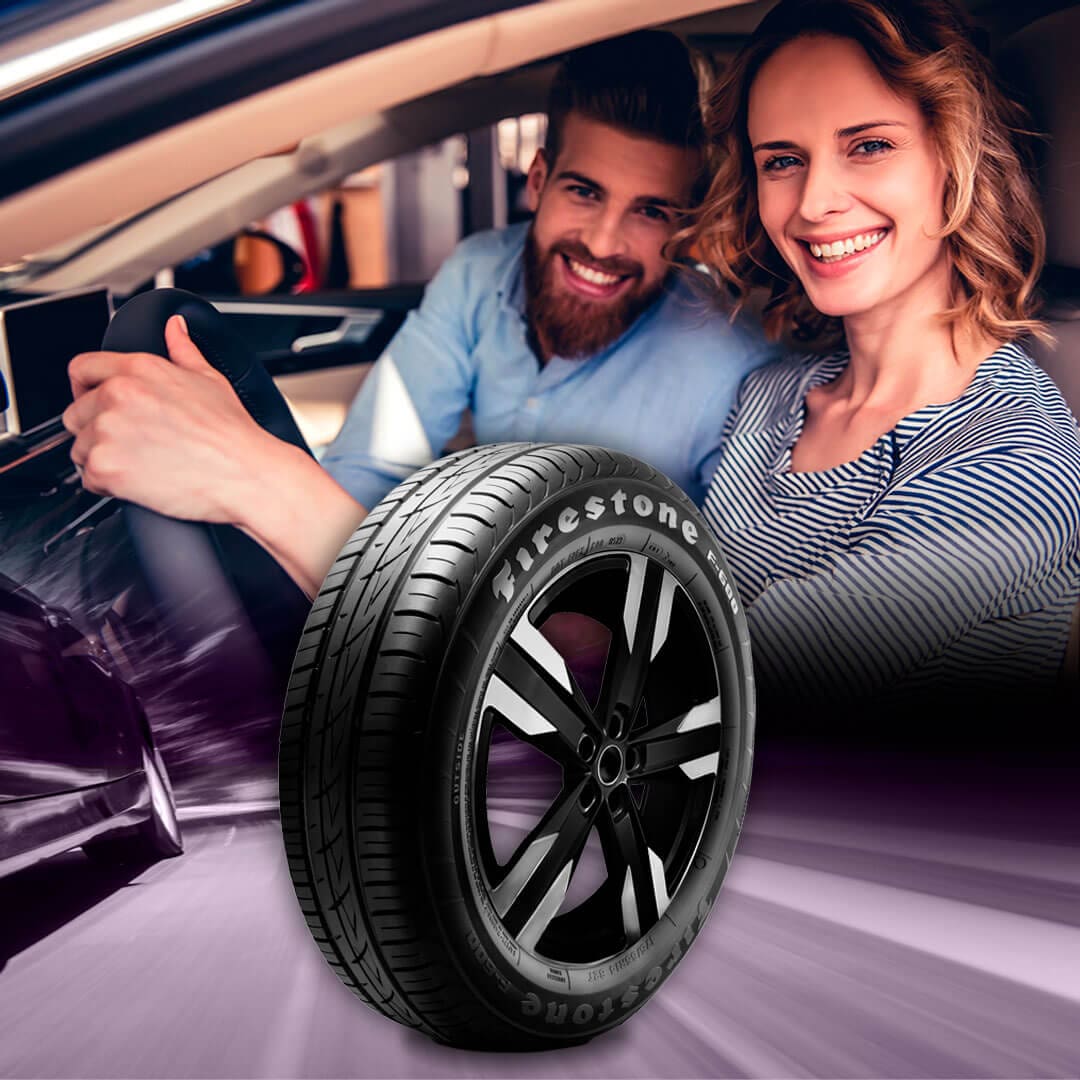 Casal dentro do carro com o Pneu Firestone F600 em evidência