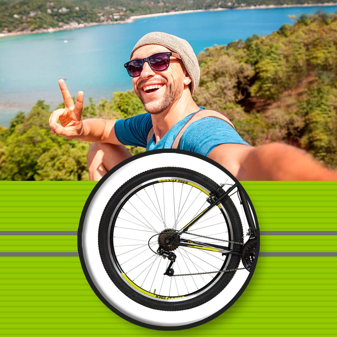 imagem frontal frente aproximada zoom roda pneu aro homem moço rapaz jovem sorrindo sorriso mão em v boina óculos escuro barba camiseta azul alto foto selfie aérea mata árvores natureza água mar rio praia areia   