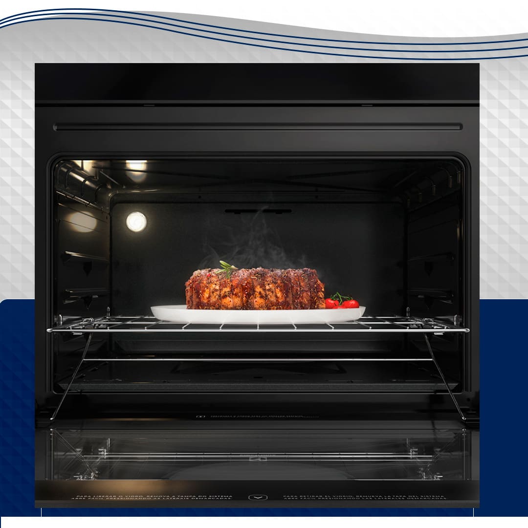 imagem frontal frente forno preto aberto parte interna exposta à mostra bolo cobertura chocolate refratário branco fumaça quente luz acesa dentro fundo  