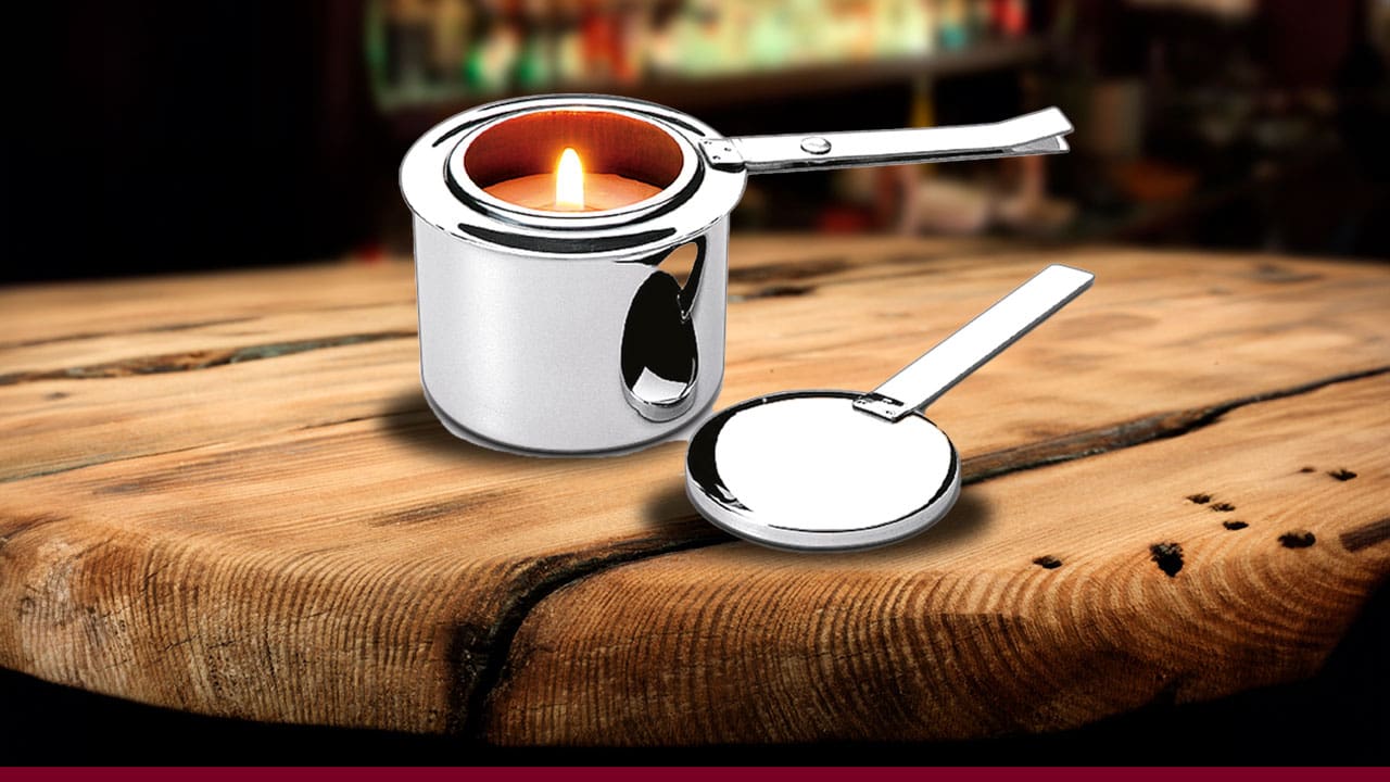 Fogareiro Brinox Savoy cinza prata aceso vela fogo tampa separada bancada marrom ambiente escuro 