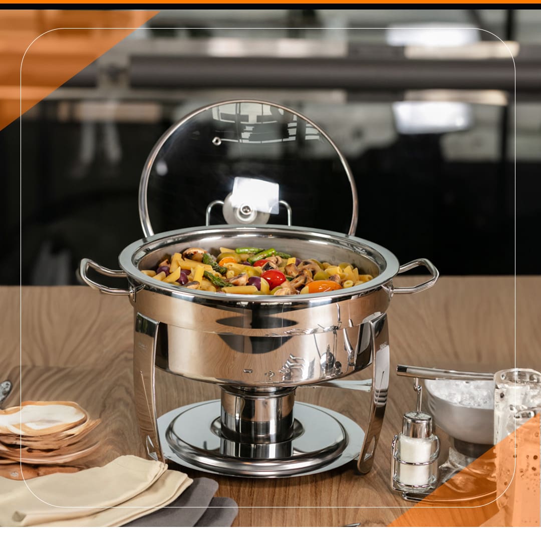 panela grande caçarola recipiente utensílio doméstico prata cinza brilho reflexo alimento macarrão legumes tomate sal saleiro guardanapos pote mesa bancada marrom madeira 