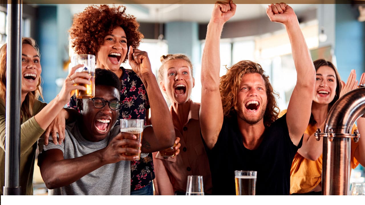 foto de pessoas comemorando com copos de cerveja na mão