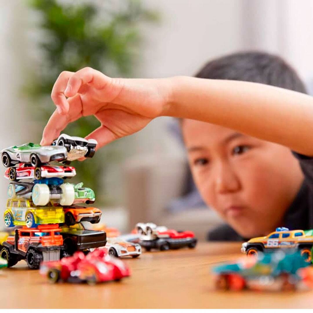 imagem mostra menino brincando com carrinhos