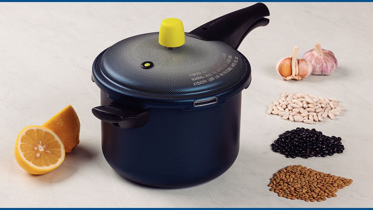 Panela de Pressão tampada com ingredientes em volta dela