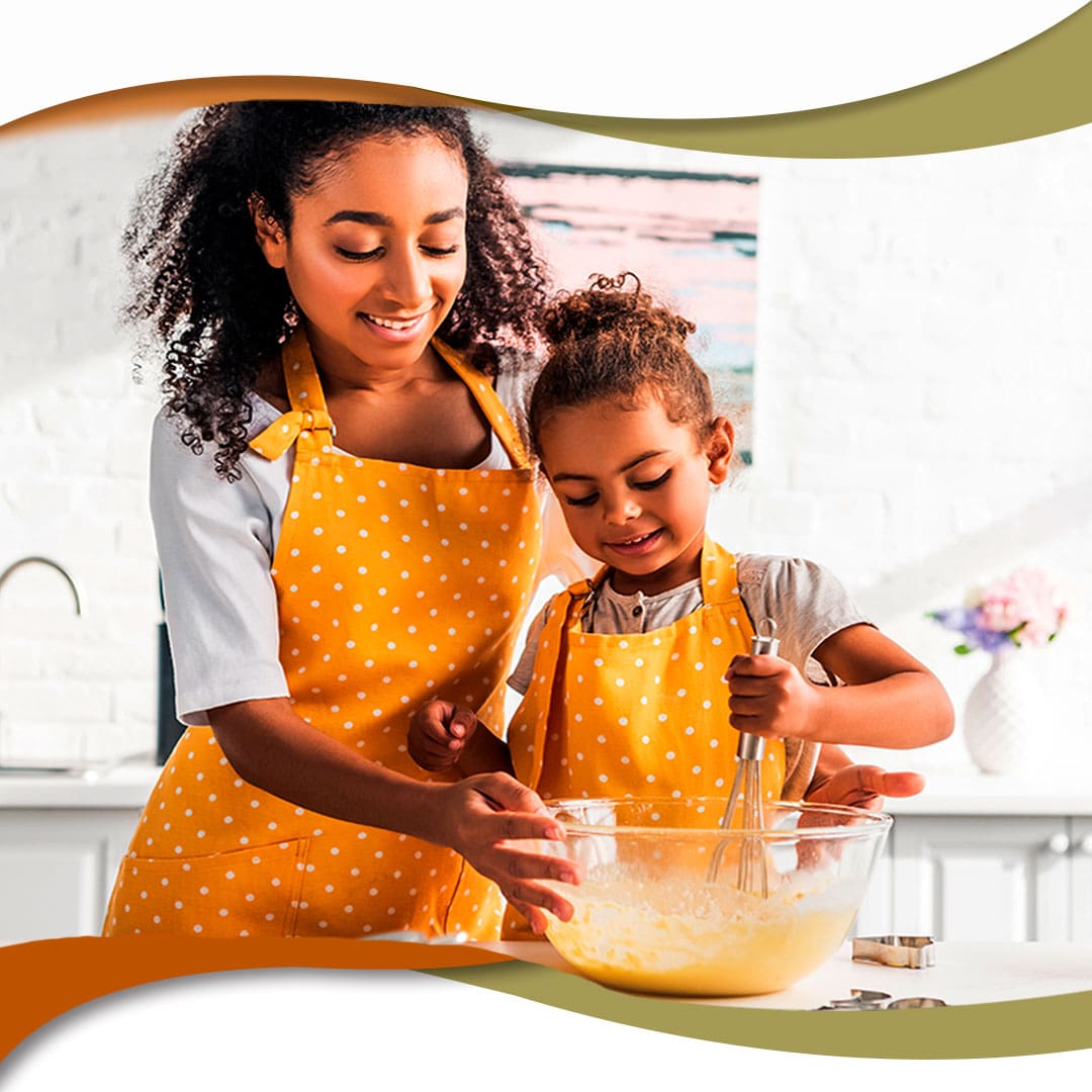 Mãe e filha preparando uma massa de bolo