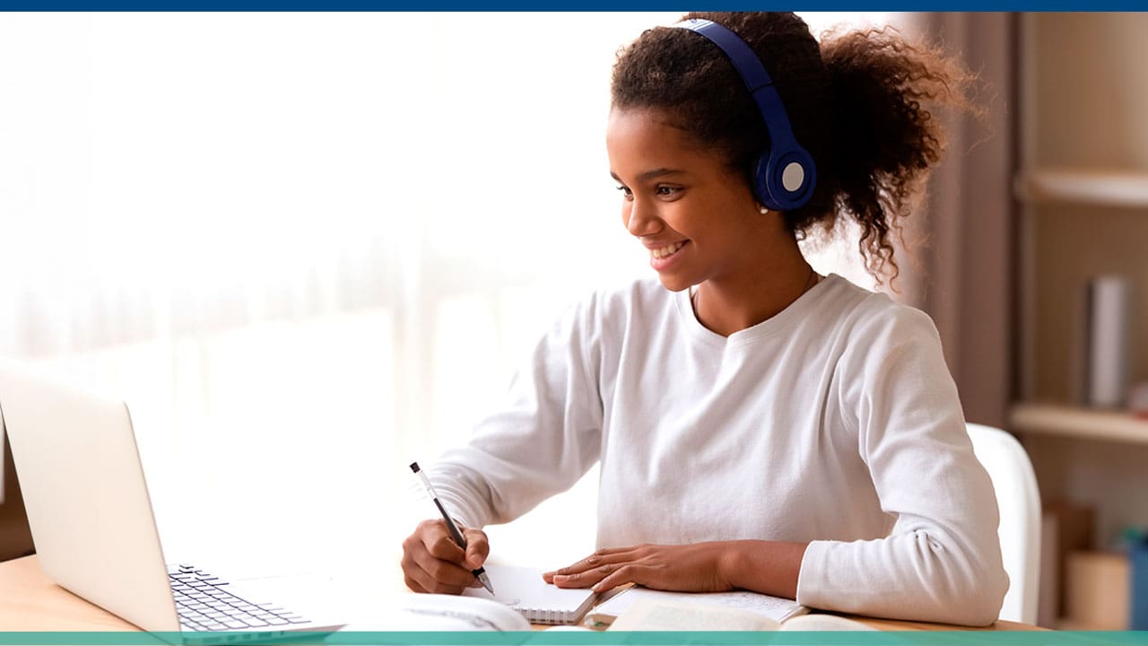 imagem mostra mulher sentada com fones de ouvido trabalhando