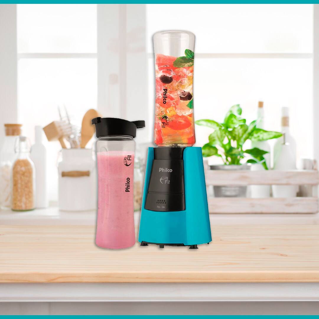 Liquidificador Philco Liq Fit azul preto estrutura transparente frutas coloridas pedras gelo folha verde vaso planta squeeze pote tampa preta fundo utensílios domésticos colher potes brancos transparentes mesa bancada marrom madeira