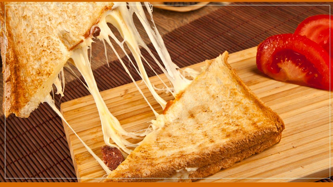 lanche metade fatiado cortado pedaço pedaços queijo derretido tomate tábua madeira
