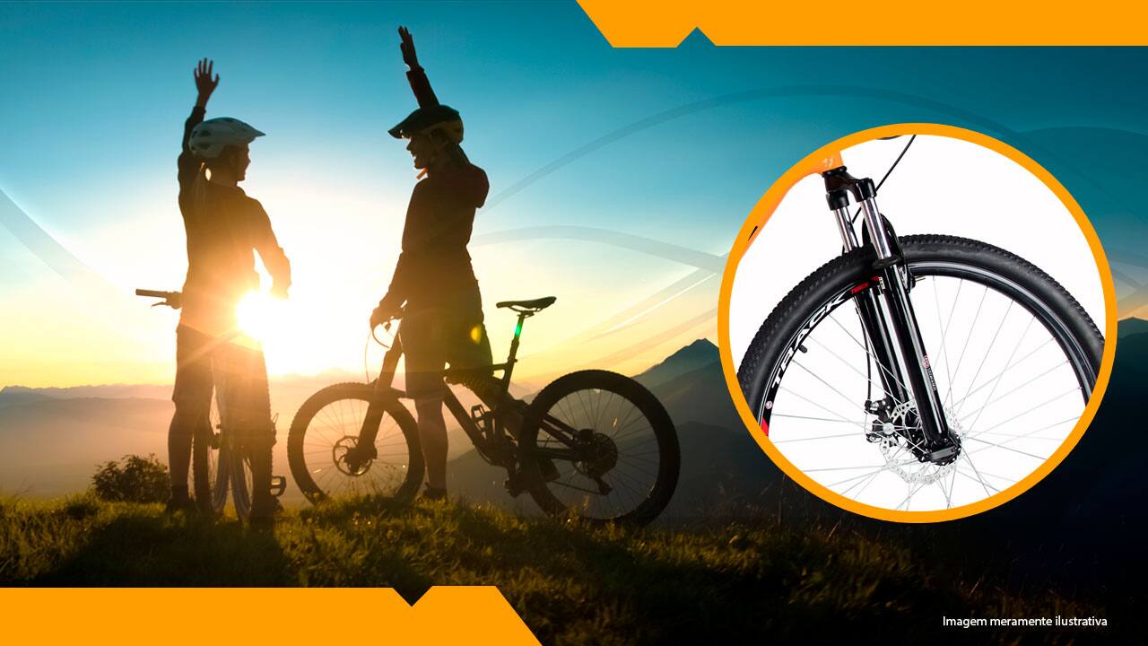 dois ciclistas em uma montanha com o pôr-do-sol a ao fundoo fundo